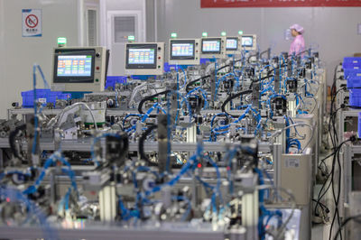 8月14日,在贛州訊康電子科技,工作人員從T1-T2全自動穿環(huán)機旁走過,該機器生產(chǎn)磁性元器件。新華社記者 才揚 攝